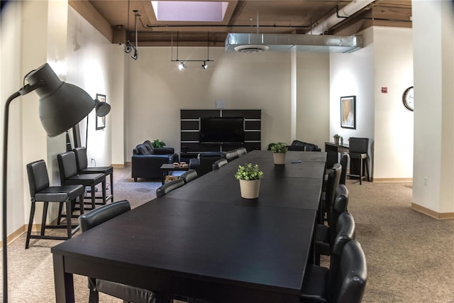 carpeted dining space featuring baseboards