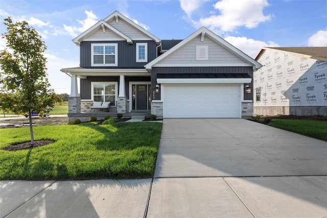 2543 Chukka Dr, Eureka, MO 63025 - craftsman-style home featuring stone siding, a front lawn, covered porch, driveway, and a garage