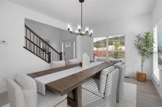 2543 Chukka Dr, Eureka, MO 63025 - dining space with a chandelier, light wood finished floors, baseboards, and stairs