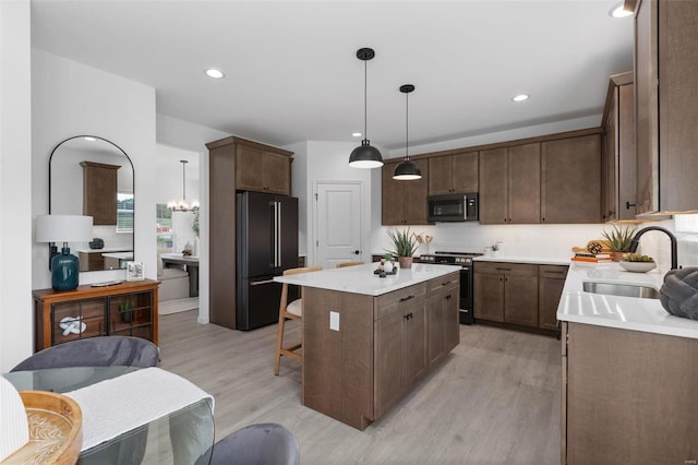 2543 Chukka Dr, Eureka, MO 63025 - kitchen featuring stainless steel range with gas cooktop, freestanding refrigerator, a sink, light wood-style floors, and a center island