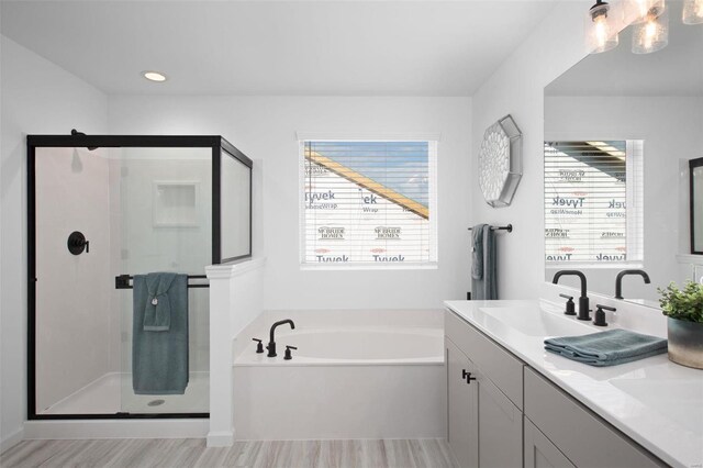 2543 Chukka Dr, Eureka, MO 63025 - bathroom featuring a bath, a stall shower, wood finished floors, and vanity