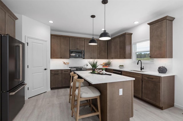 2543 Chukka Dr, Eureka, MO 63025 - kitchen with high end black fridge, a sink, light wood-type flooring, a center island, and recessed lighting
