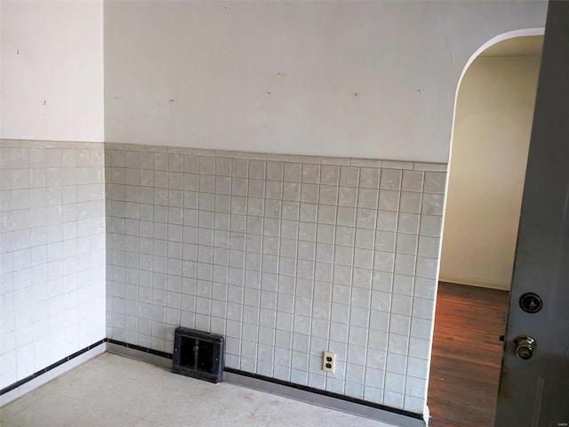 700 Pershing St E, St Louis, IL 62203 - empty room with arched walkways, tile walls, and wood finished floors