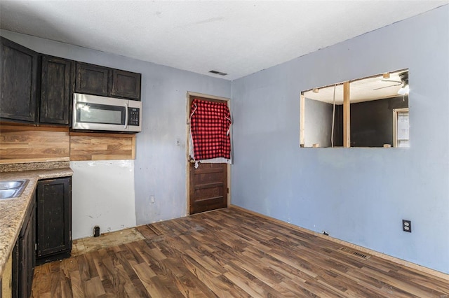 8 Crescent Dr, Viburnum, MO 65566 - kitchen featuring stainless steel microwave, wood finished floors, light countertops, and a sink