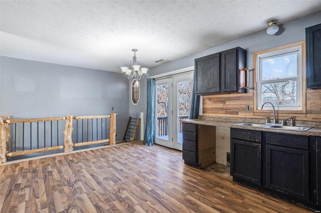 8 Crescent Dr, Viburnum, MO 65566 - kitchen with a sink, dark wood-style floors, a textured ceiling, a chandelier, and pendant lighting