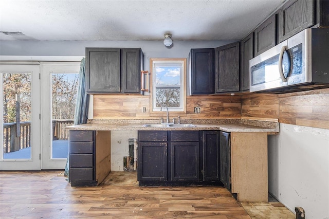 8 Crescent Dr, Viburnum, MO 65566 - kitchen featuring stainless steel microwave, a sink, plenty of natural light, wood finished floors, and a textured ceiling