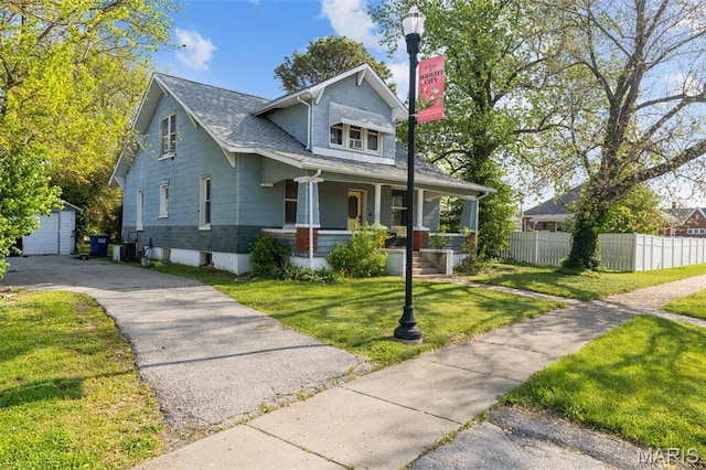 205 W 2nd St N, Wright City, MO 63390 - view of front of home with a porch, an outdoor structure, roof with shingles, central air condition unit, and driveway