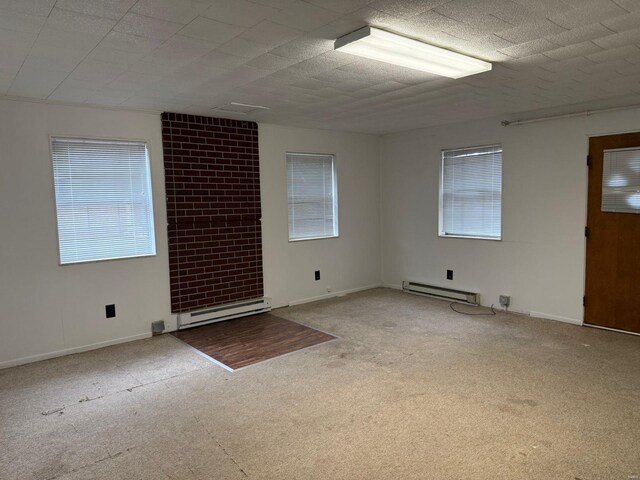 carpeted spare room with a baseboard radiator and plenty of natural light