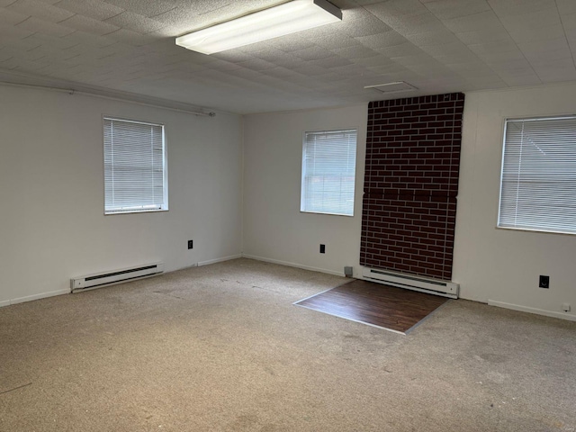 carpeted empty room with baseboard heating and baseboards