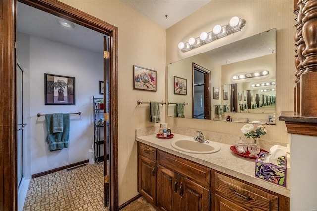 full bath with vanity, baseboards, tile patterned floors, and a shower with shower door