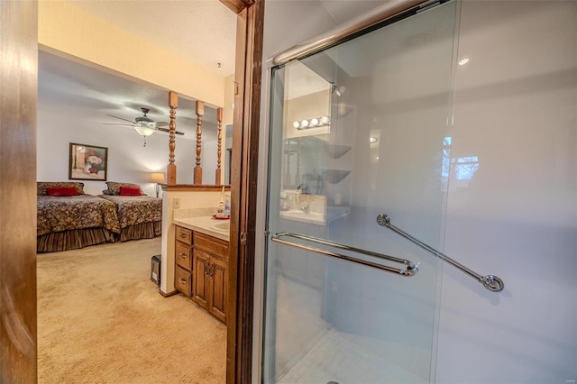 ensuite bathroom featuring a shower stall, ceiling fan, and vanity