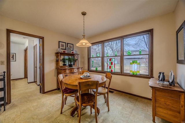 dining space with plenty of natural light, baseboards, and light flooring