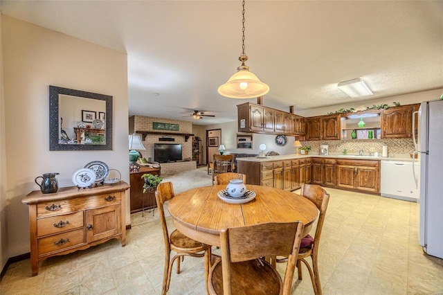 dining room featuring light floors, a fireplace, and a ceiling fan