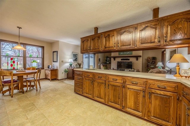 kitchen featuring brown cabinetry, healthy amount of natural light, and light countertops