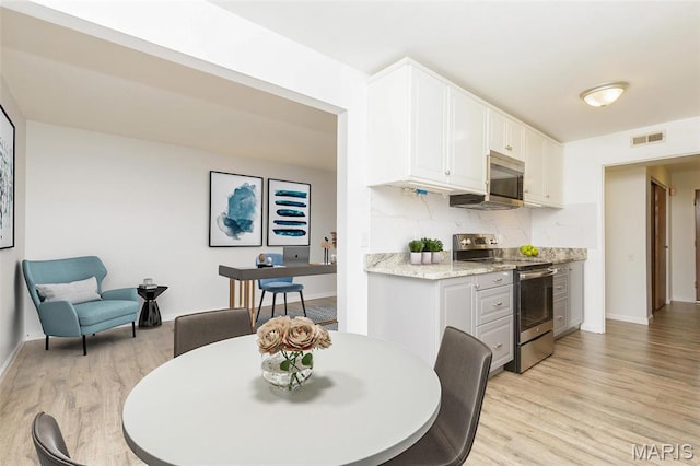 585 Coeur De Royale Dr Unit 201, Saint Louis, MO 63141 - kitchen with appliances with stainless steel finishes, light wood finished floors, white cabinetry, and baseboards