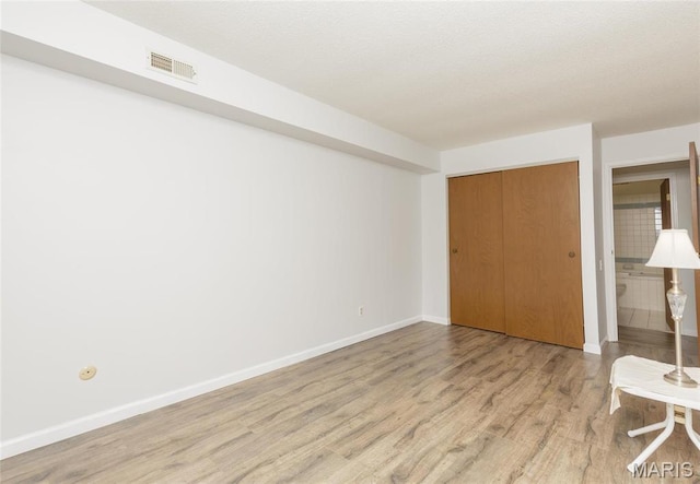 585 Coeur De Royale Dr Unit 201, Saint Louis, MO 63141 - unfurnished bedroom with light wood-style flooring, baseboards, and a closet