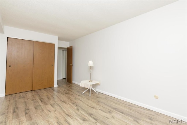 585 Coeur De Royale Dr Unit 201, Saint Louis, MO 63141 - unfurnished bedroom featuring light wood-style floors, baseboards, and a closet