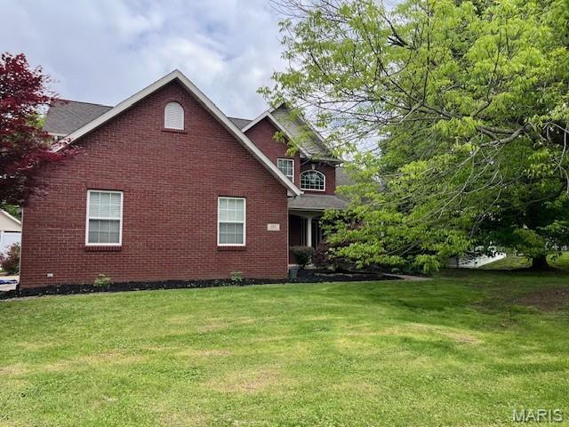 view of front facade featuring a front lawn and brick siding