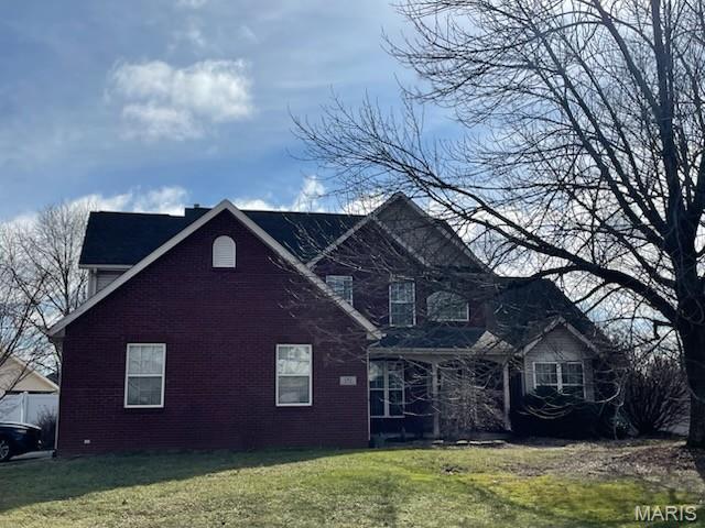 view of front of property with brick siding and a front lawn