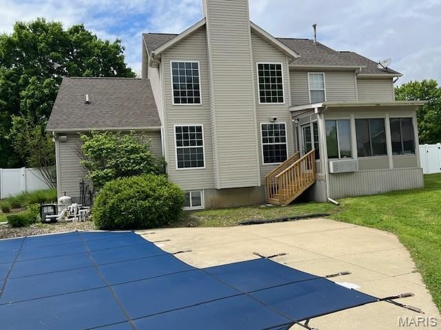 back of house featuring a sunroom, a chimney, a patio area, and fence