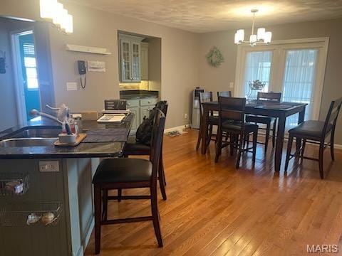 dining area featuring a chandelier, light wood-type flooring, and baseboards