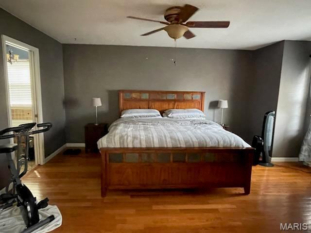 bedroom featuring light wood-style floors, baseboards, and a ceiling fan