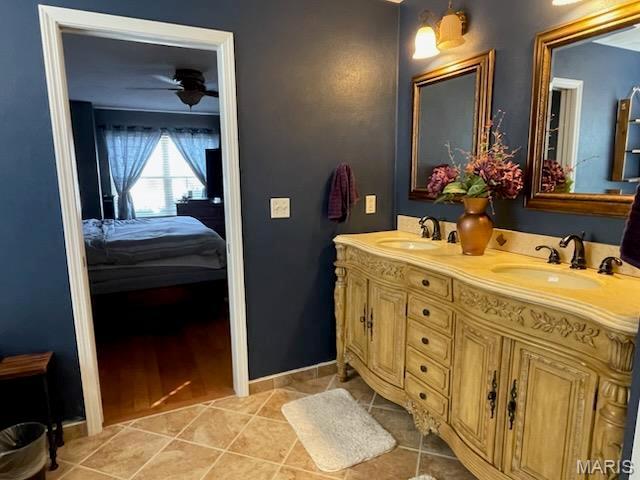 ensuite bathroom with tile patterned flooring, double vanity, and a ceiling fan