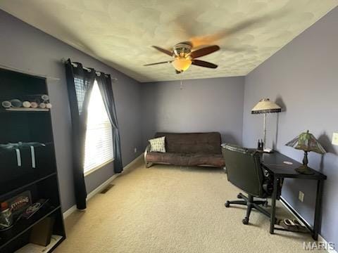 carpeted office space featuring healthy amount of natural light, a ceiling fan, and baseboards