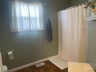 full bath with toilet and a shower with shower curtain
