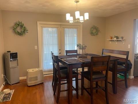 dining area featuring a chandelier, wood finished floors, and baseboards