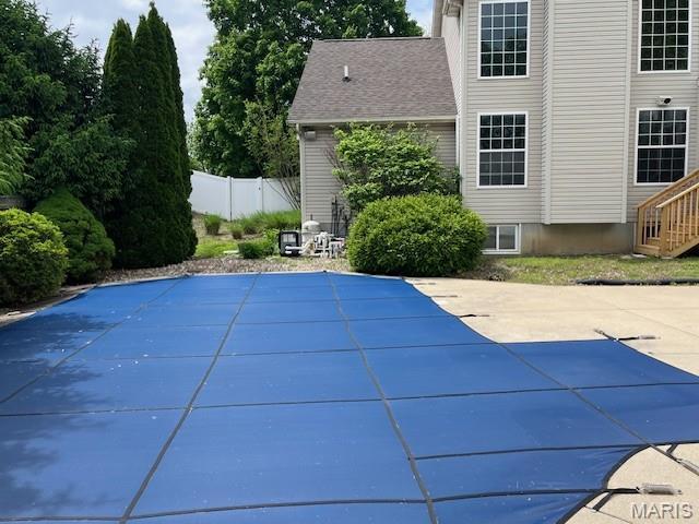 view of swimming pool with a patio and fence