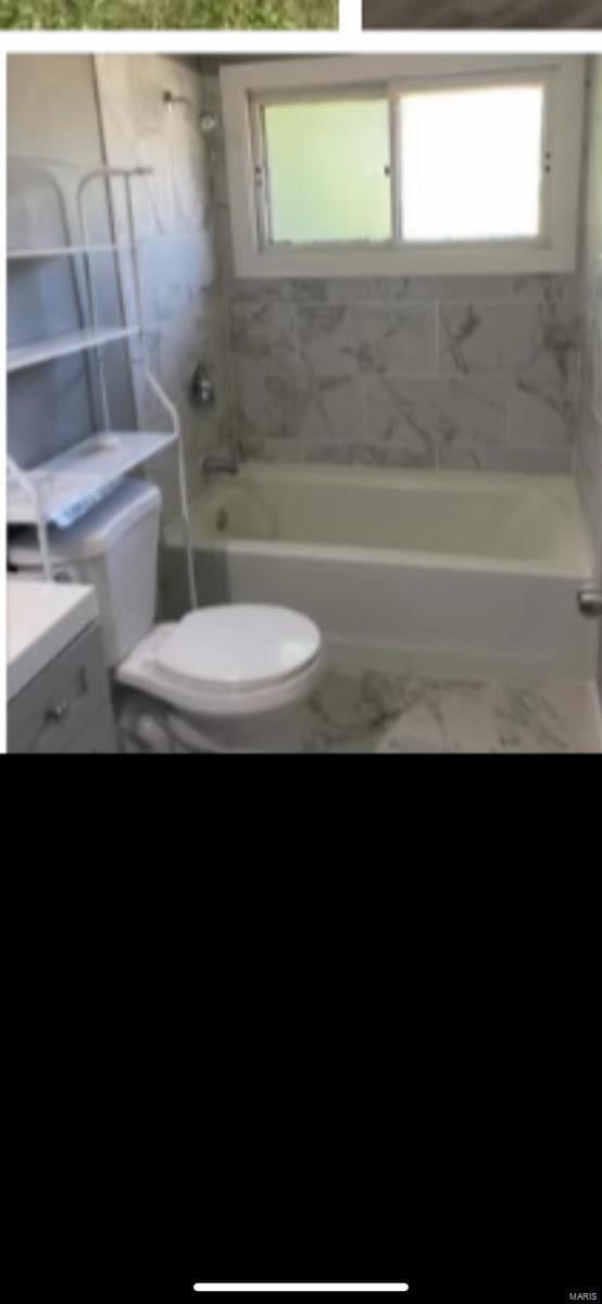 805 Derhake Rd, Florissant, MO 63033 - full bathroom featuring toilet, shower / bath combination, and marble look tile flooring