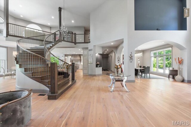 2535 S Lindbergh Blvd, Saint Louis, MO 63131 - entrance foyer with arched walkways, stairs, a towering ceiling, hardwood / wood-style flooring, and a chandelier