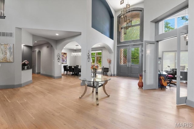 2535 S Lindbergh Blvd, Saint Louis, MO 63131 - entrance foyer with a high ceiling, arched walkways, light wood-type flooring, a chandelier, and baseboards
