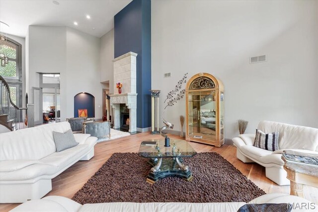 2535 S Lindbergh Blvd, Saint Louis, MO 63131 - living room with high vaulted ceiling, a warm lit fireplace, wood finished floors, recessed lighting, and baseboards