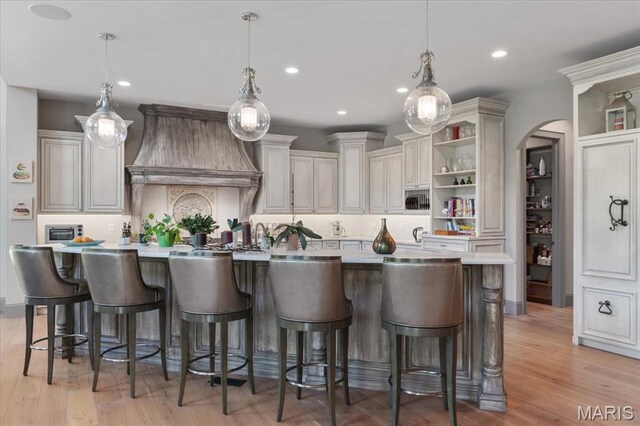 2535 S Lindbergh Blvd, Saint Louis, MO 63131 - kitchen with open shelves, light countertops, custom exhaust hood, recessed lighting, and light wood-style flooring