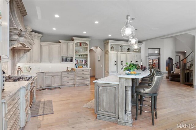 2535 S Lindbergh Blvd, Saint Louis, MO 63131 - kitchen with open shelves, arched walkways, light wood finished floors, recessed lighting, and a breakfast bar