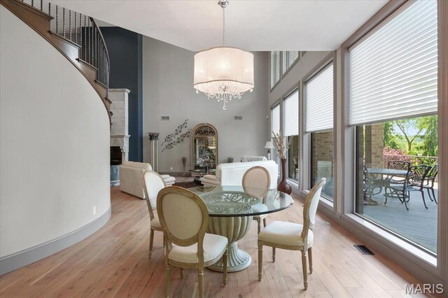 2535 S Lindbergh Blvd, Saint Louis, MO 63131 - dining space with a chandelier, light wood finished floors, a high ceiling, stairs, and baseboards