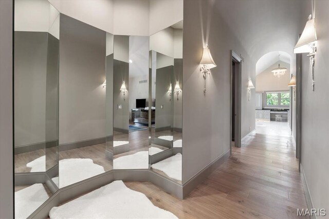 2535 S Lindbergh Blvd, Saint Louis, MO 63131 - corridor featuring baseboards, light wood-type flooring, a chandelier, and high vaulted ceiling