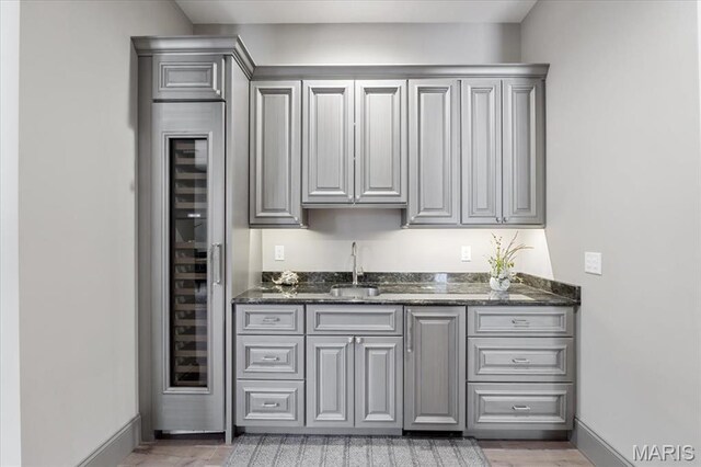 2535 S Lindbergh Blvd, Saint Louis, MO 63131 - indoor wet bar featuring baseboards, light wood-style flooring, and wine cooler