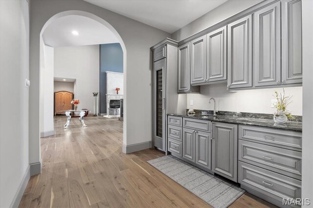 2535 S Lindbergh Blvd, Saint Louis, MO 63131 - bar with arched walkways, a sink, light wood finished floors, baseboards, and recessed lighting