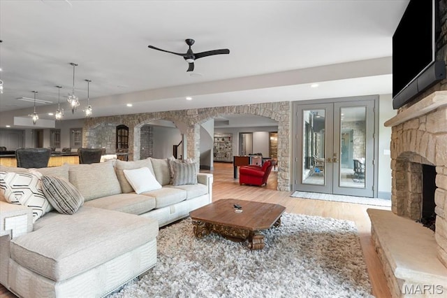 2535 S Lindbergh Blvd, Saint Louis, MO 63131 - living area with arched walkways, wood finished floors, french doors, ceiling fan, and a fireplace