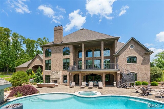 2535 S Lindbergh Blvd, Saint Louis, MO 63131 - back of house with a balcony, an in-ground hot tub, stairway, a patio area, and a chimney