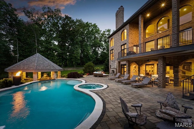 2535 S Lindbergh Blvd, Saint Louis, MO 63131 - pool at dusk featuring a gazebo, a patio, and a pool with connected hot tub