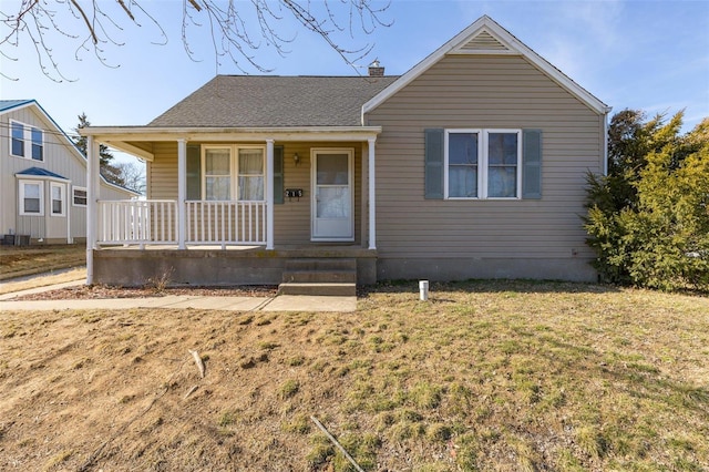 215 Virginia St, Saint Genevieve, MO 63670 - view of front of home featuring a porch, a front yard, and a chimney