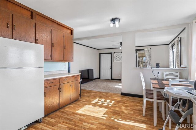 215 Virginia St, Saint Genevieve, MO 63670 - kitchen with freestanding refrigerator, a ceiling fan, brown cabinetry, and light wood-style floors