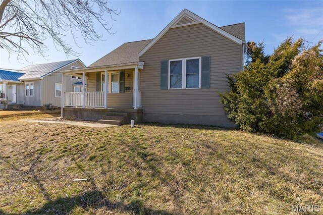 215 Virginia St, Saint Genevieve, MO 63670 - bungalow-style home featuring covered porch and a front lawn