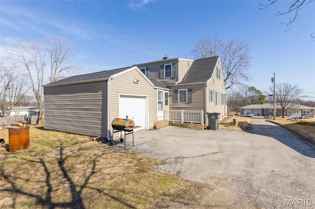 215 Virginia St, Saint Genevieve, MO 63670 - back of property with asphalt driveway, a garage, and a chimney