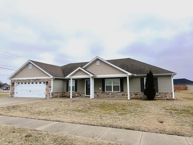 view of front of house with stone siding, an attached garage, covered porch, roof with shingles, and driveway