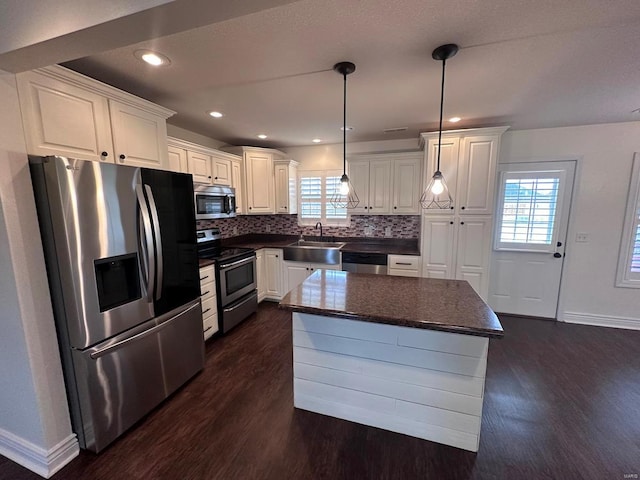 kitchen with appliances with stainless steel finishes, dark wood-style flooring, dark countertops, tasteful backsplash, and recessed lighting